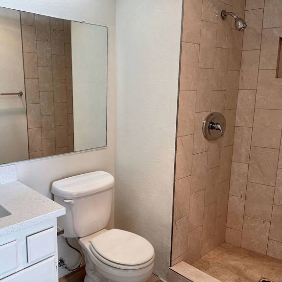 Thumbnail 23 of 26 A white toilet sits next to a sink in a bathroom.