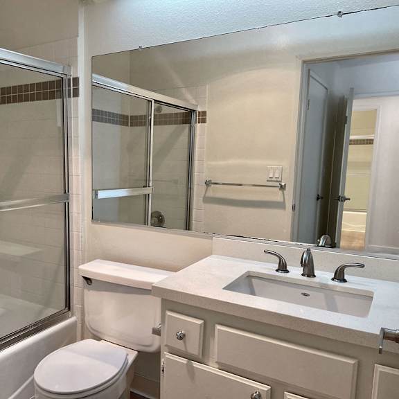 Thumbnail 8 of 11 A white toilet sits next to a sink in a bathroom.