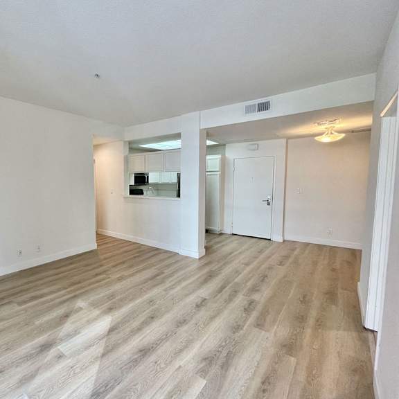 Thumbnail 3 of 11 A room with a fireplace and wood flooring.