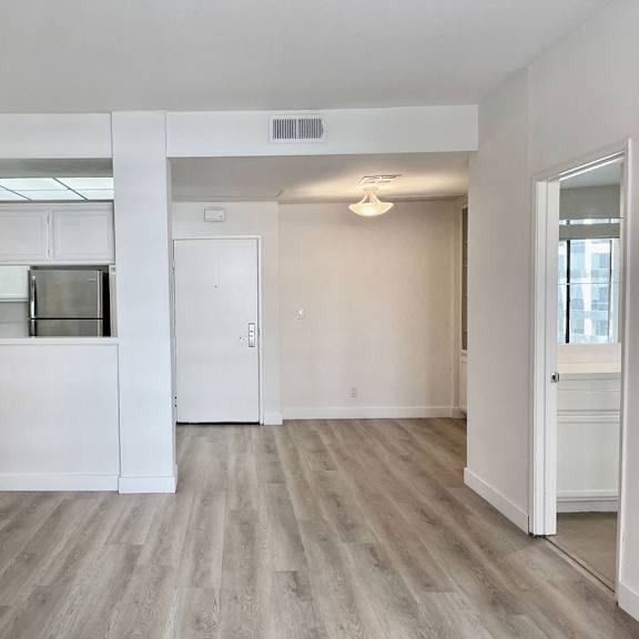 Thumbnail 9 of 11 A kitchen with white cabinets and a microwave built into the cabinetry.