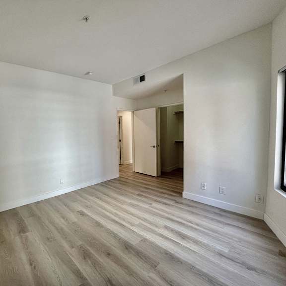 Thumbnail 11 of 11 A room with wooden flooring and white walls.