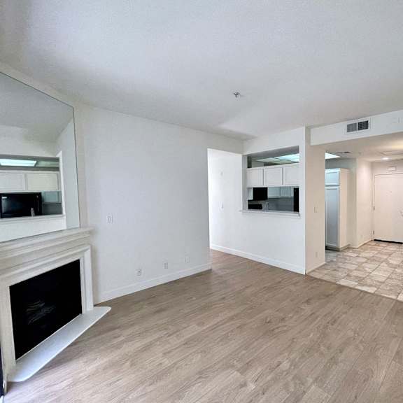 Thumbnail 22 of 53 A spacious living room with a fireplace and hardwood flooring.