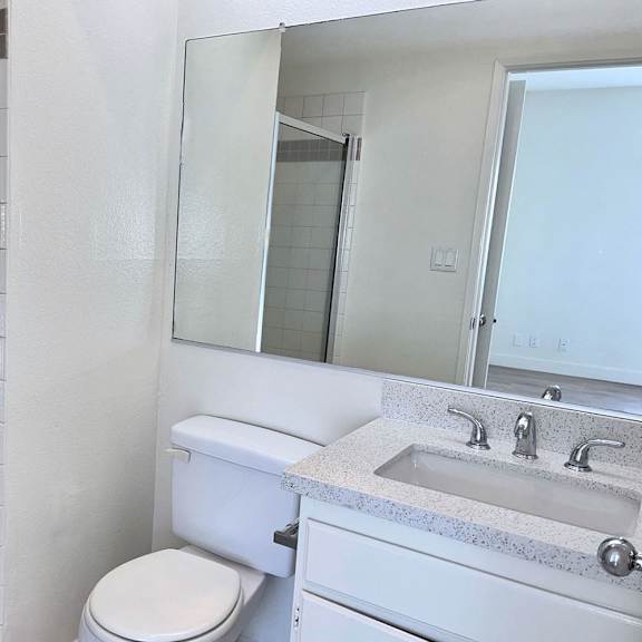 Thumbnail 31 of 53 A white toilet sits next to a sink in a bathroom.