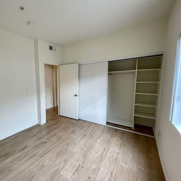 Thumbnail 25 of 53 A room with a white wall and a wooden floor.