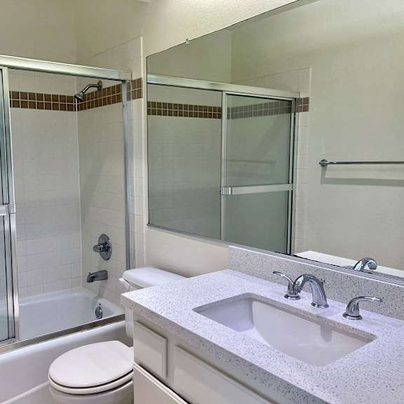 Thumbnail 24 of 53 A white toilet sits next to a sink in a bathroom.