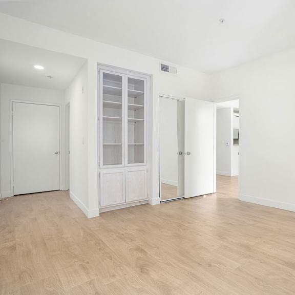 Thumbnail 16 of 21 A room with a white door and a white cabinet with glass doors.