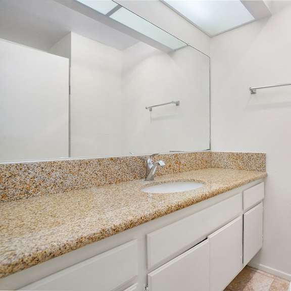 Thumbnail 9 of 21 A bathroom with a toilet, sink, and mirror.