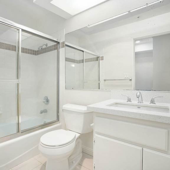 Thumbnail 37 of 39 A white bathroom with a toilet, sink, and shower.