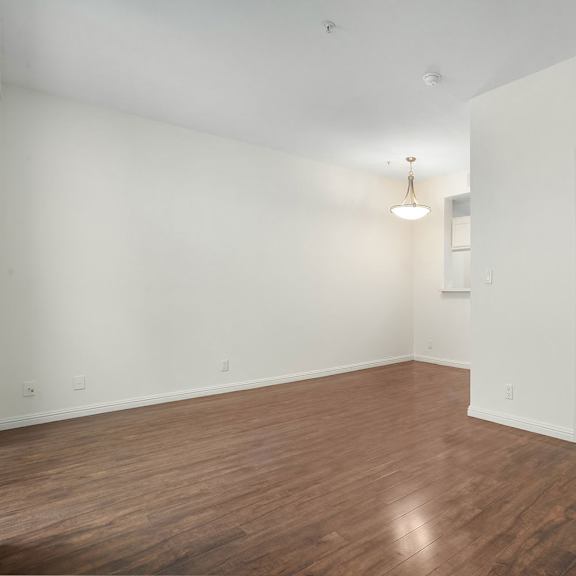 Thumbnail 36 of 39 A room with a wooden floor and a white door.