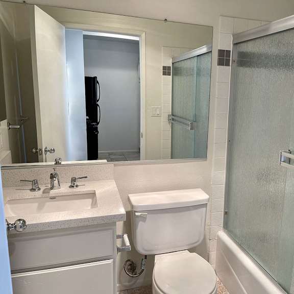 Thumbnail 24 of 39 A white toilet sits next to a sink in a bathroom.