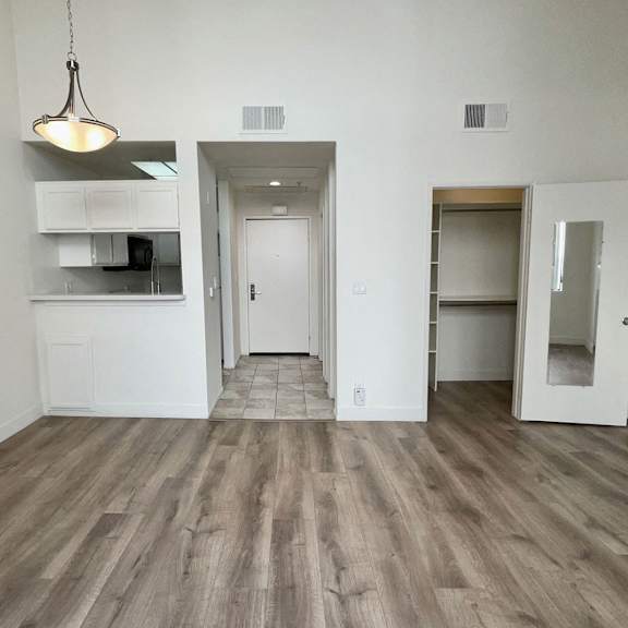 Thumbnail 6 of 8 A room with a wooden floor and white walls.