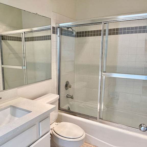 Thumbnail 3 of 8 A white bathroom with a sink, toilet, and shower.