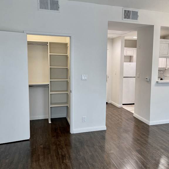 Thumbnail 6 of 6 A kitchen area with a refrigerator, cabinets, and a countertop.