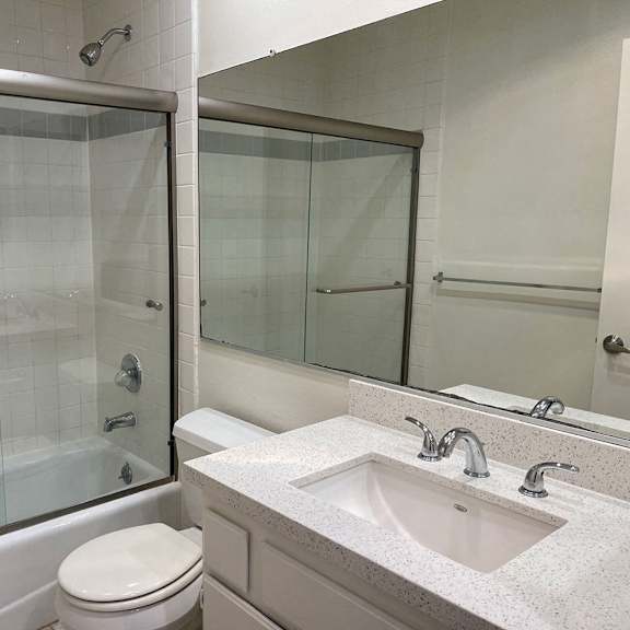 Thumbnail 5 of 6 A white toilet sits next to a sink in a bathroom.