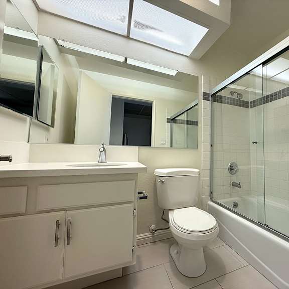 Thumbnail 28 of 39 A white toilet is in a bathroom with a glass shower stall.