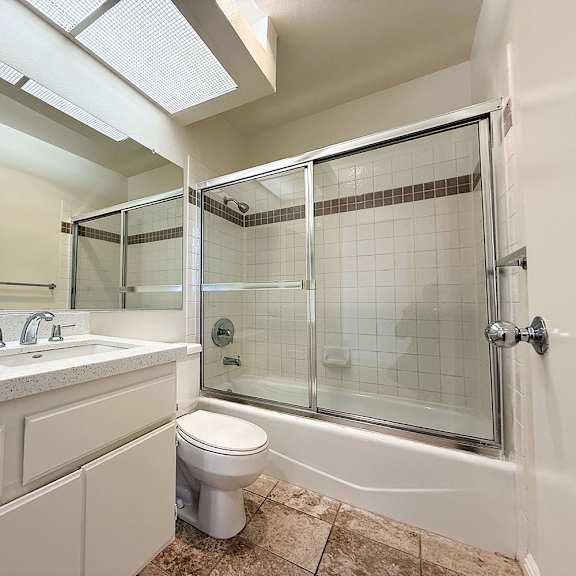 Thumbnail 5 of 26 A white bathroom with a toilet, sink, and shower.