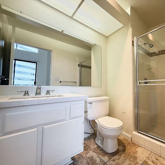 Thumbnail 7 of 26 A white bathroom with a walk in shower.