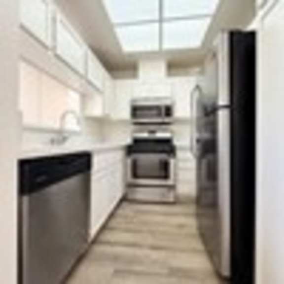 Thumbnail 33 of 53 A modern kitchen with a dishwasher, oven, and refrigerator.