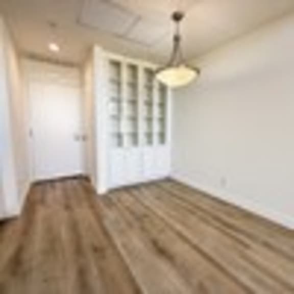 Thumbnail 34 of 53 A long hallway with wood floors and white walls.