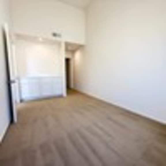 Thumbnail 38 of 53 A room with a white wall and a brown carpet.