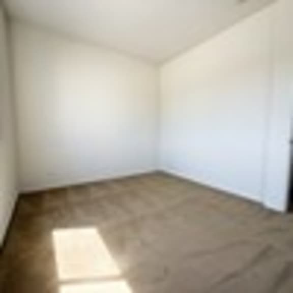 Thumbnail 53 of 53 A room with white walls and a brown carpet.