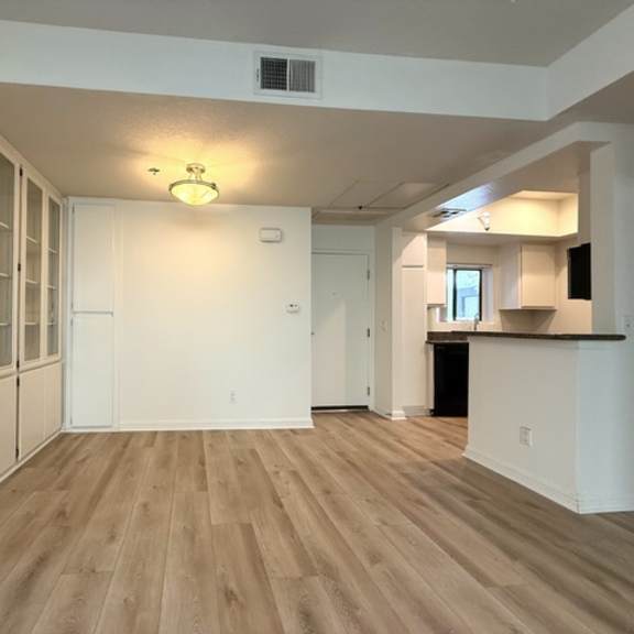 Thumbnail 10 of 26 A room with wooden flooring and white walls.