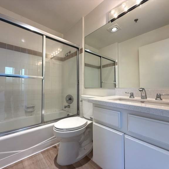 Thumbnail 21 of 26 A white bathroom with a toilet, sink, and shower.