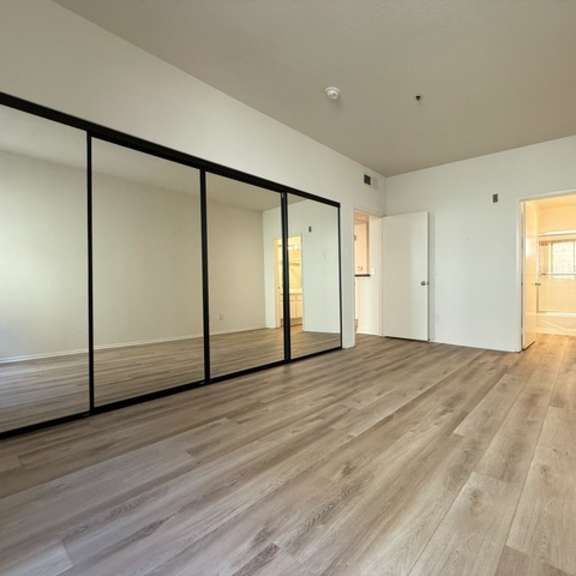 Thumbnail 17 of 26 A room with wooden flooring and a sliding door.