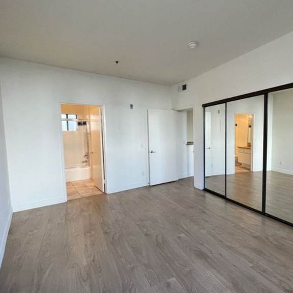 Thumbnail 8 of 11 A room with a sliding door and wood flooring.