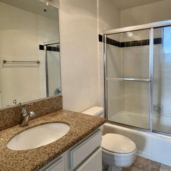 Thumbnail 9 of 11 A bathroom with a sink, toilet, and shower.