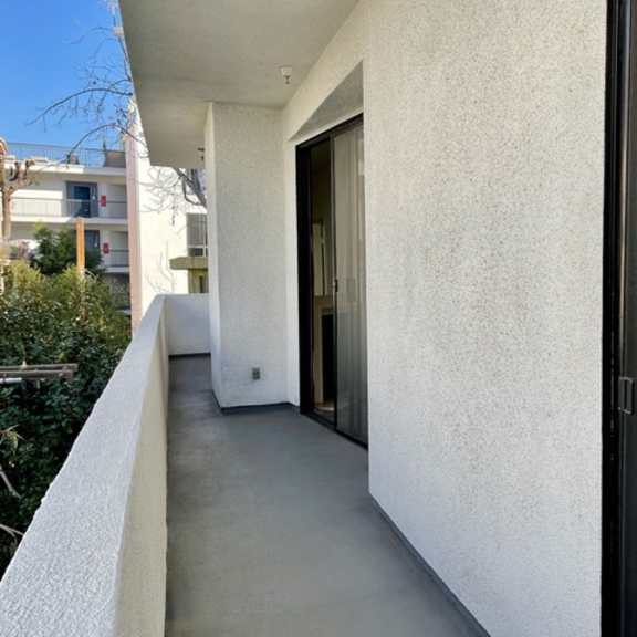Thumbnail 4 of 11 A white building with a glass door and window.