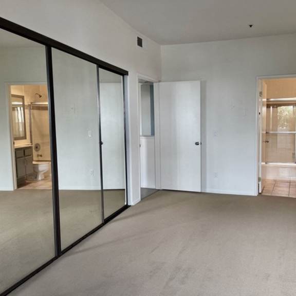 Thumbnail 11 of 11 A room with white walls and carpeted floor with a glass door.