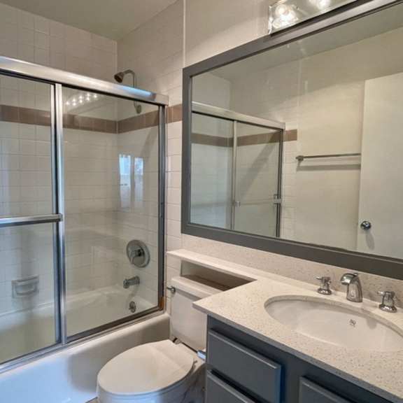 Thumbnail 3 of 11 A modern bathroom with a toilet, sink, and shower.