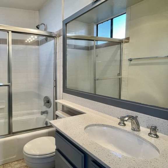 Thumbnail 2 of 11 A bathroom with a toilet, sink, and shower.