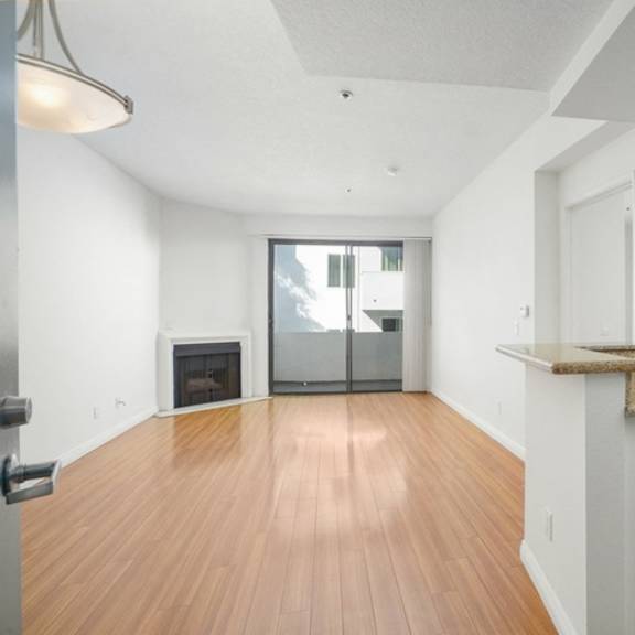 Thumbnail 7 of 14 A kitchen with a wooden floor and white cabinets.
