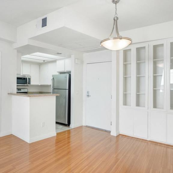 Thumbnail 12 of 14 A kitchen with white cabinets and a wooden floor.