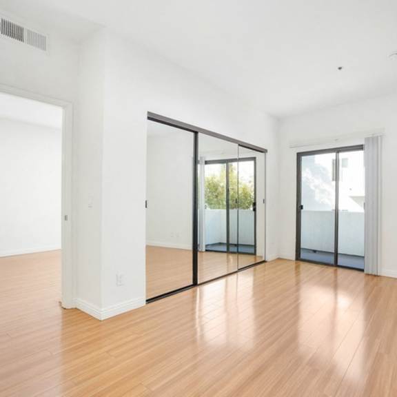 Thumbnail 9 of 14 A room with wooden floors and white walls.