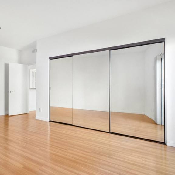 Thumbnail 13 of 14 A room with wooden floors and white walls.