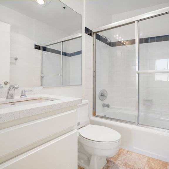 Thumbnail 9 of 17 A white bathroom with a toilet, sink, and shower.