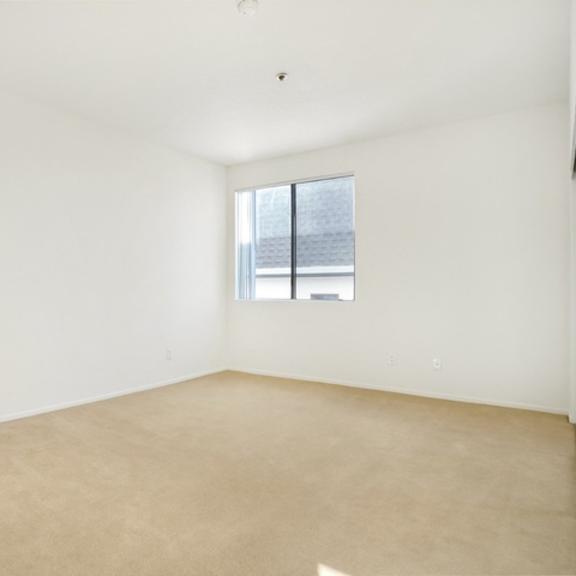 Thumbnail 16 of 17 Empty room with a window and carpeted floor.