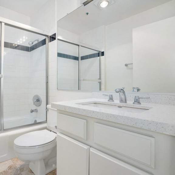 Thumbnail 3 of 17 A white bathroom with a toilet, sink, and shower.