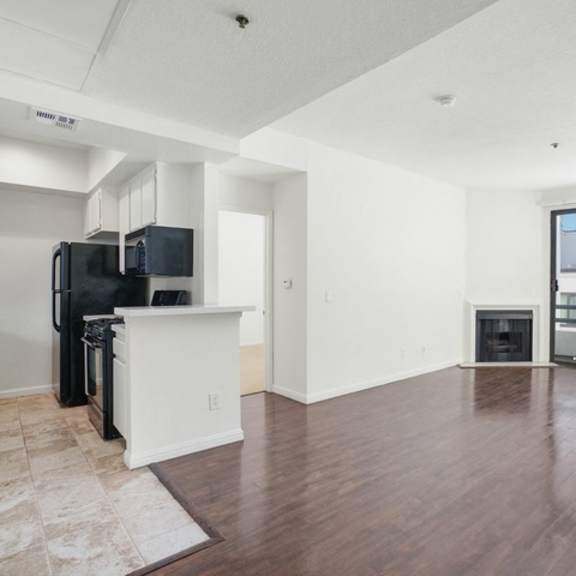 Thumbnail 11 of 17 A spacious living room with a kitchenette and a view of the city.