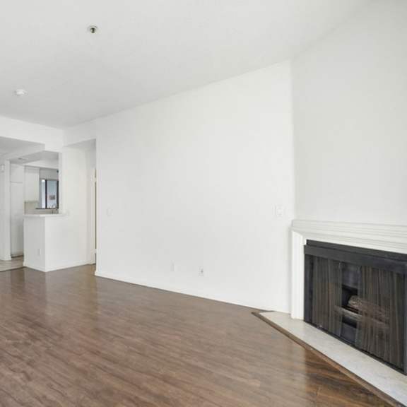 Thumbnail 13 of 17 A living room with a fireplace and wood flooring.