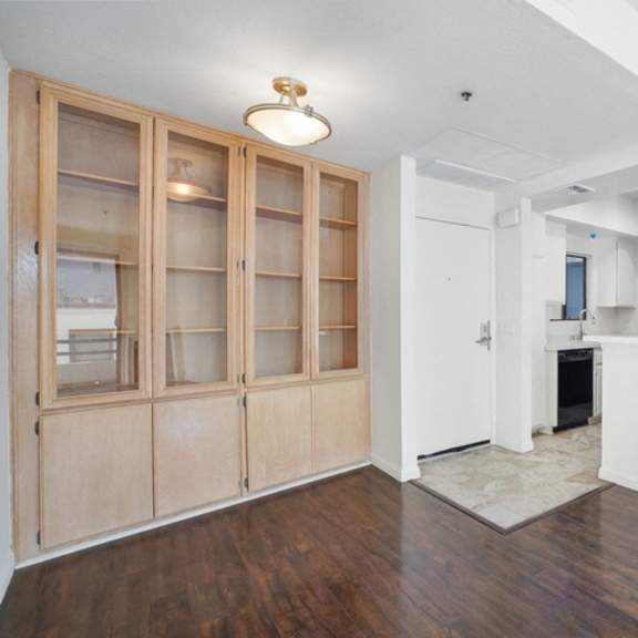 Thumbnail 6 of 17 A room with a white wall and a wooden floor.