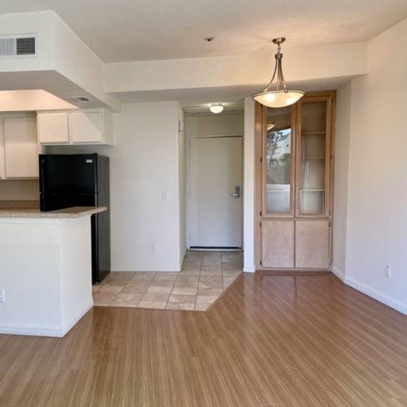 Thumbnail 9 of 18 A kitchen with a black fridge and white cabinets.