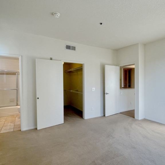 Thumbnail 16 of 18 A large empty room with a doorway leading to a bathroom.