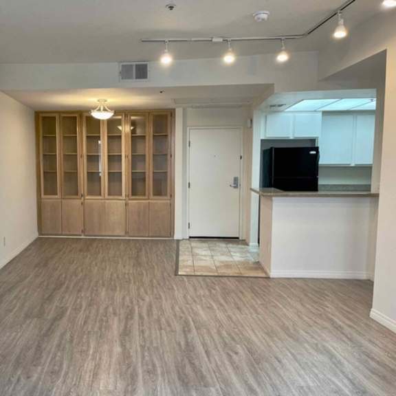 Thumbnail 4 of 8 A spacious room with wooden flooring and a built-in cabinet.