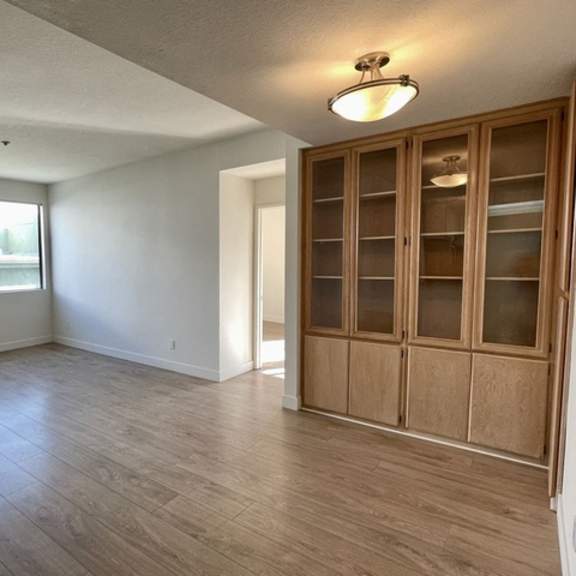 Thumbnail 20 of 26 A room with wooden floors and a fireplace.