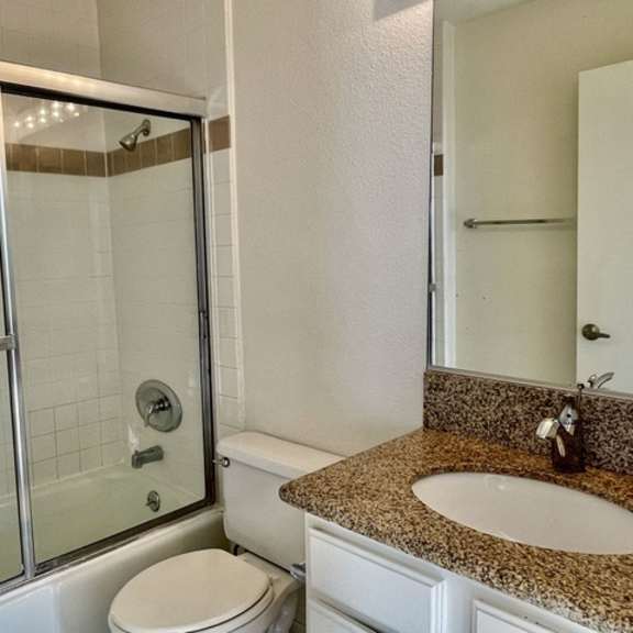 Thumbnail 23 of 26 A bathroom with a toilet, sink, and shower.