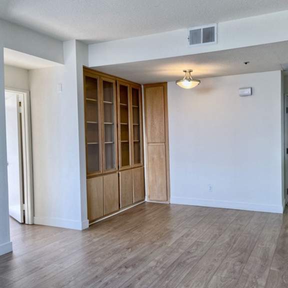 Thumbnail 15 of 26 A room with a white wall and a wooden floor.